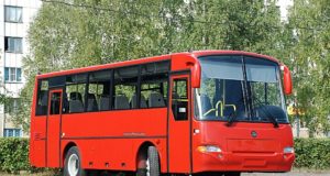 GAZ Buses Bright Red Bus Parked in Font of Trees