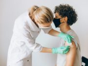 Costa Rican migrants Nurse Vaccinating Man